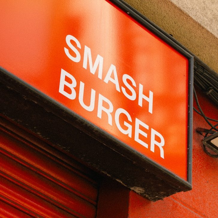 Werbetechnik & Außenwerbung Sign mit der Aufschrift "SMASH BURGER" auf rotem Hintergrund.